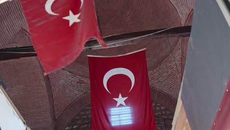 bandera turca roja colgando del techo de un edificio de ladrillo