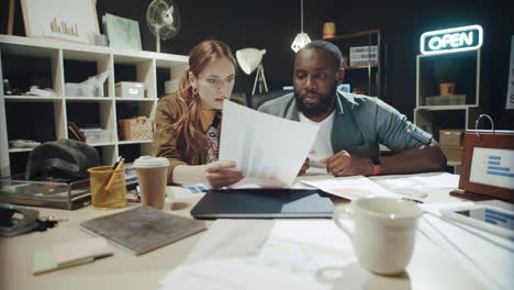 Stressed-multi-ethnic-professionals-checking-project-in-hipster-office