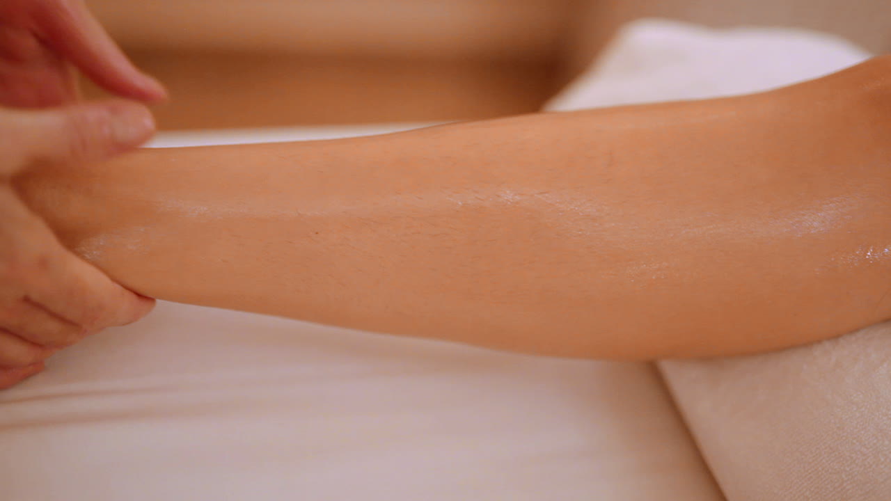 Purificazione della pelle del ginocchio tramite massaggio manuale con olio in una spa.