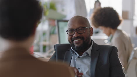 Un-Hombre-De-Negocios-Afroamericano-Charlando-Con-Un-Pasante-Discutiendo-Una-Entrevista-De-Trabajo-Con-Colegas-Conversando-En-La-Oficina-Disfrutando-Del-Trabajo-En-Equipo