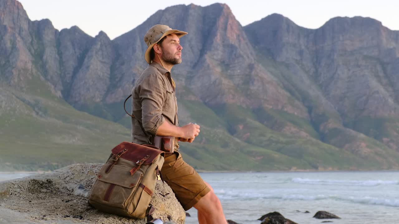 un hombre con un sombrero de safari hace una foto en la puesta de sol del océano ciudad del cabo áfrica