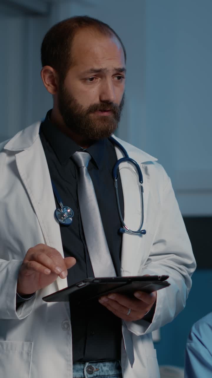 Vertical video: Doctor holding tablet computer typing patient diagnosis expertise