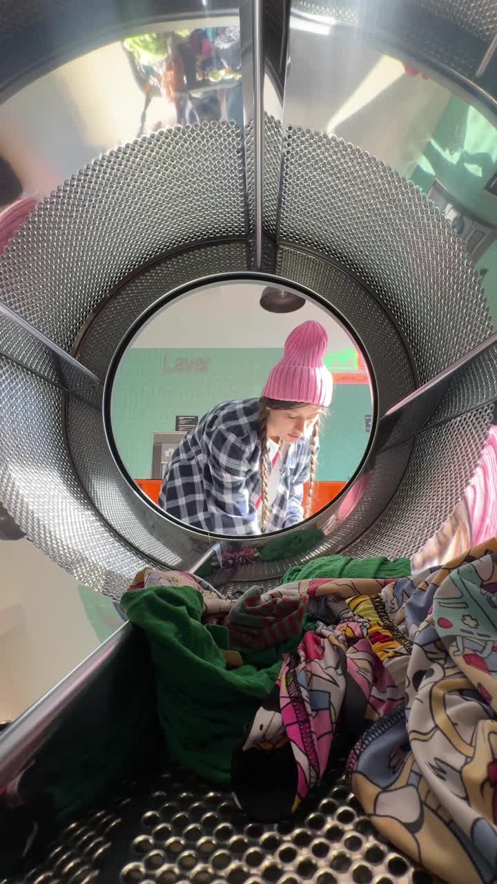 adolescente cargando la ropa en la lavadora