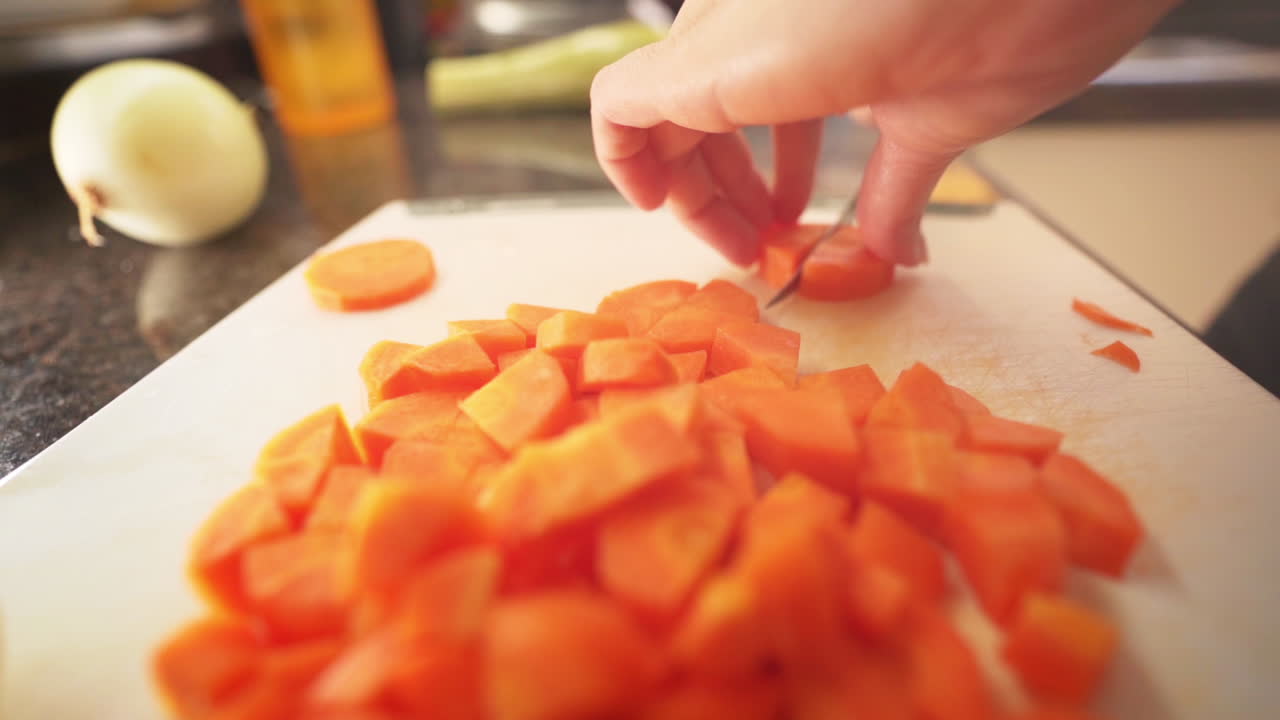 manos femeninas cortando zanahorias en la cocina en una tabla de cortar