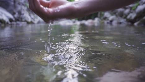 hand and drops coming out of water.