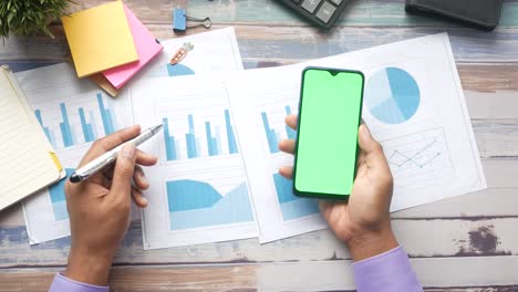 persona que revisa informes empresariales en un teléfono inteligente