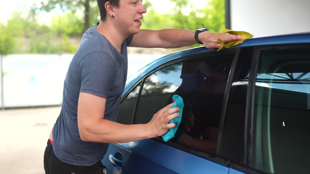 hombre limpiando una ventana de coche