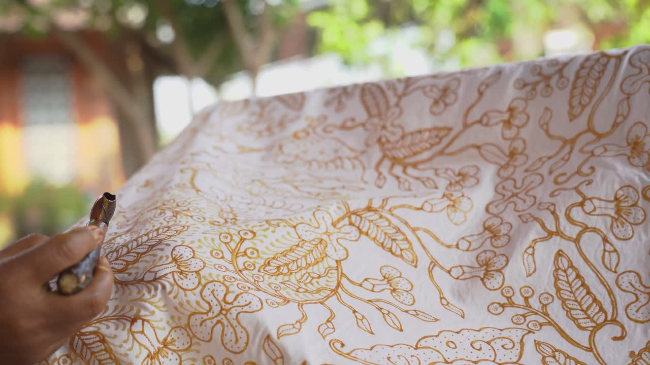 The technique of making hand-drawn batik using a canting tool. This craftsman is making batik typical of Giriloyo Bantul Yogyakarta.