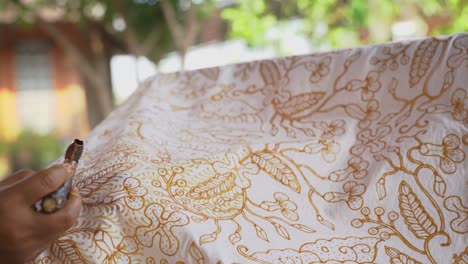 the technique of making hand-drawn batik using a canting tool. this craftsman is making batik typical of giriloyo bantul yogyakarta.
