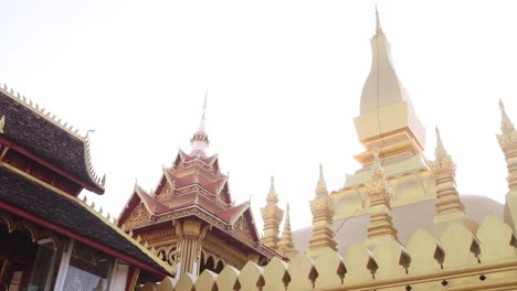 pequeño templo frente a pha que luang estupa dorada templo budista en vientiane, laos