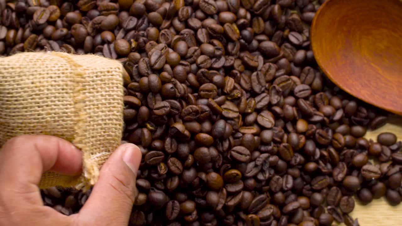 4k 영상 4096x2304p: 향기로운 커피 콩이 김판에 여 있으며, 커피 에서 연기가 나옵니다. 전체 구성은 카메라 주위를 천천히 스크롤합니다.