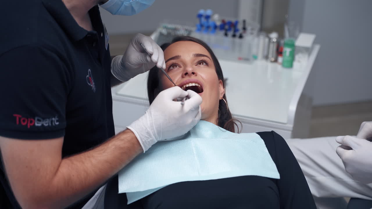 Treatment process at dental clinic. Dentist treating teeth of woman patient