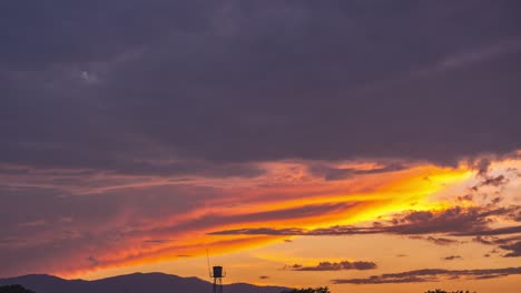 4k timlapse of dramatic sunset. heavy rain clouds rolling in the orange sky. rainy season weather forecasting. colorful bright hot yellow sunlight and thick clouds on the mountain. nature scenery vdo.