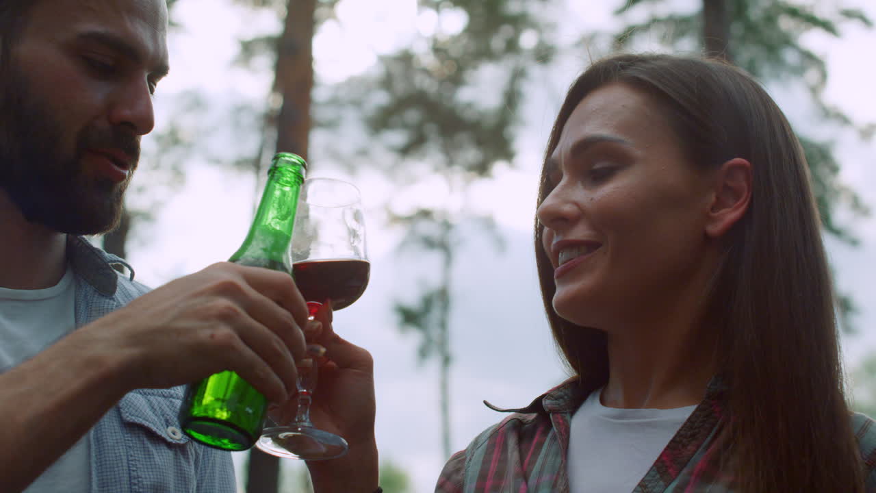 jóvenes haciendo sonar copas afuera. amigos alegres divirtiéndose en una fiesta de barbacoa