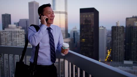 ethnic male business manager using smartphone at sunrise