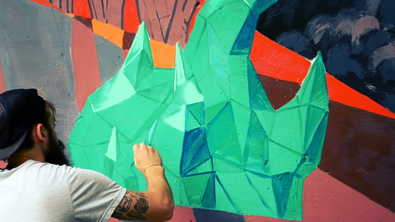 L'artista realizza graffiti su una recinzione. Disegno astratto