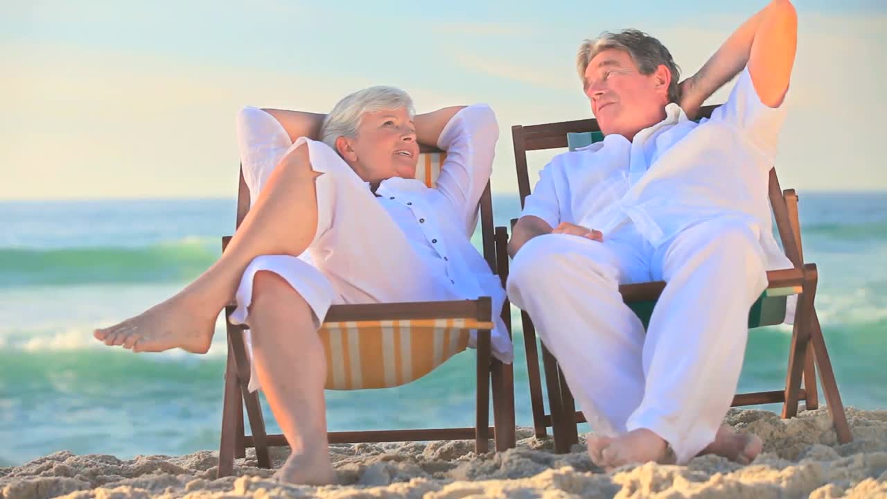 Mature couple sitting in deck chairs