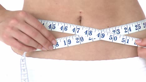 young cute woman measuring her waist with a tape measure