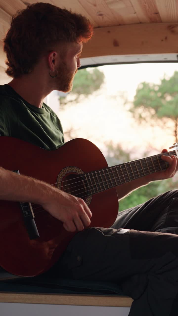 Man playing guitar in a van