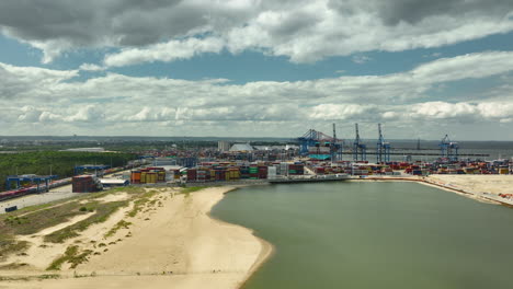 Aerial-view-of-a-bustling-port-with-shipping-containers,-cranes,-and-industrial-facilities