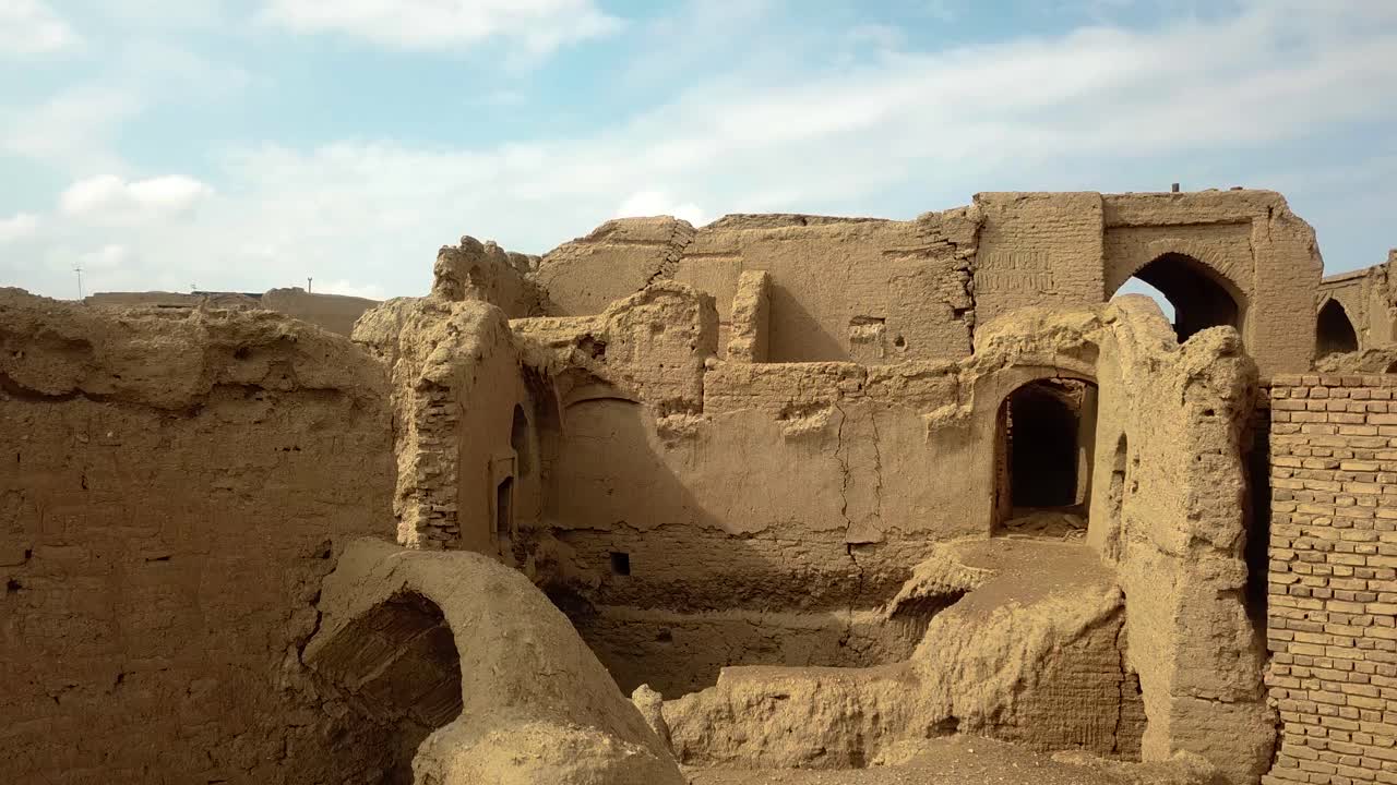 Walking with drone shot view in a village with mud brick material design architectural asian middle esst asia ruins of persia empire fly wide view of a village life local people