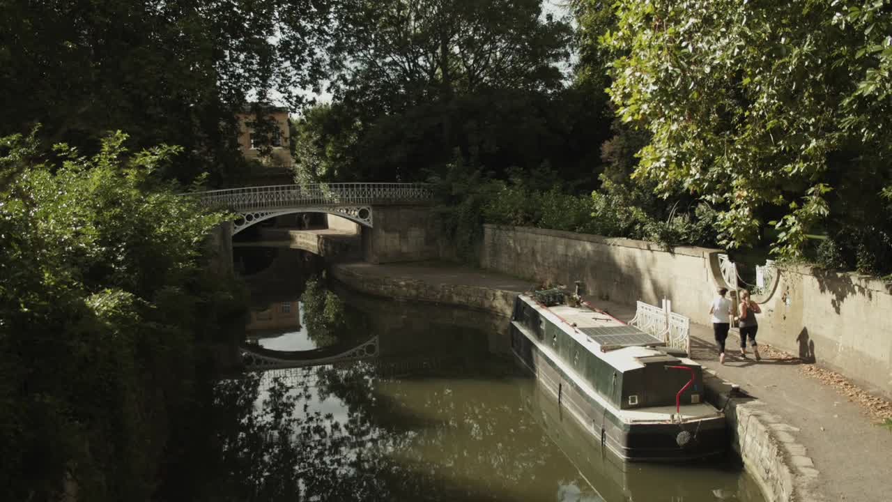 Due signore anziane che fanno jogging lungo il Canale Kennet e Avon a Bath ed entrano nei Giardini di Sydney