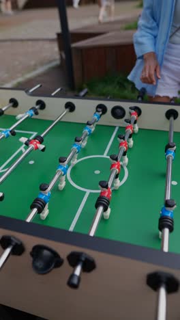 mujer jugando al futbolín al aire libre