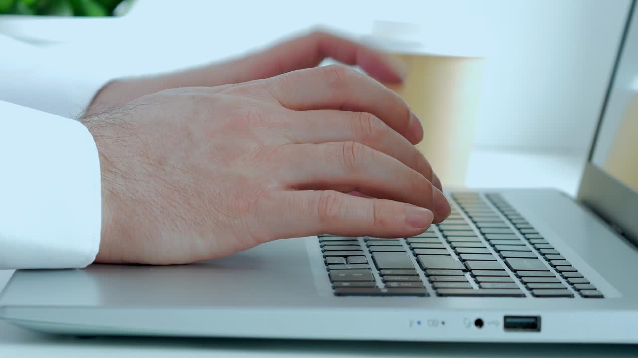 A man is working at a laptop. Close-up.He presses the keyboard buttons with his fingers