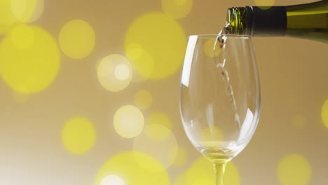 compuesto de vino blanco que se vierte en un vaso sobre manchas amarillas