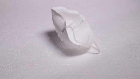 falling protective white mask mask against threats like corona covid-19 virus on white substrate that protects mouth and nose on plate capture in 4k 60fps