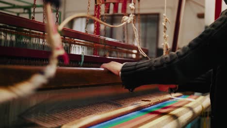 weaver-weaving-threads-on-traditional-loom-producing-colorful-textiles