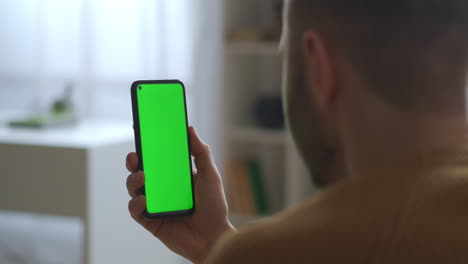 El-Tipo-Está-Mirando-La-Pantalla-Verde-De-Un-Teléfono-Inteligente-Que-Sostiene-Un-Dispositivo-Verticalmente-Moderno-Y-Una-Aplicación-Para-Educación,-Comunicación-Y-Entretenimiento,-Vista-De-Primer-Plano