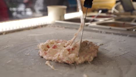 slowmo - preparation of sweet handmade stir-fried rolled ice cream dessert thai style at food festival