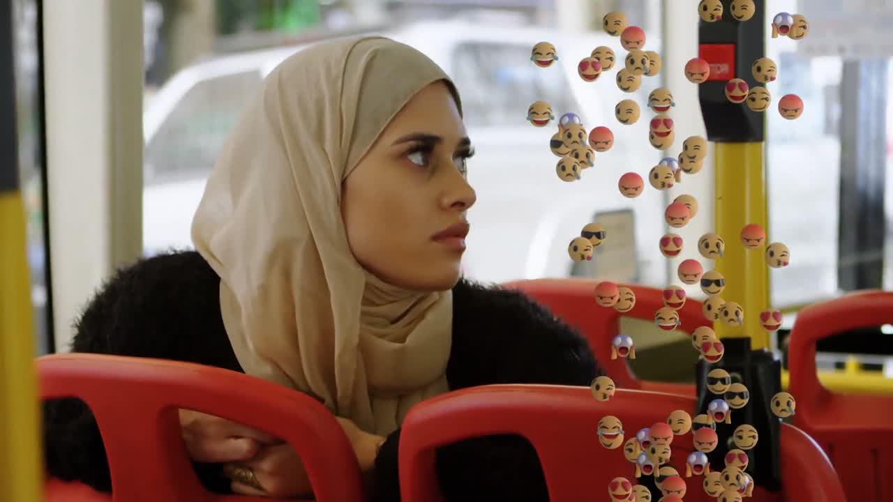 animación de emojis que caen sobre una mujer con hijab usando un teléfono inteligente