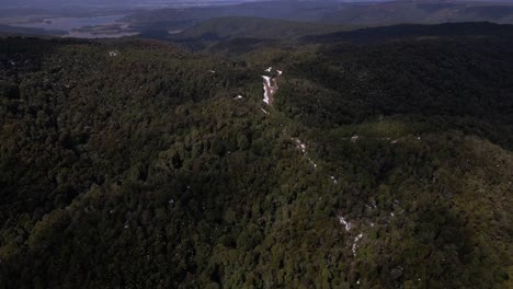 aerial pan out video of road in the middle of the mountains with the coast in the back, landscape in oncol park in chile