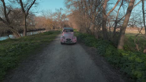 Slow-tilting-shot-revealing-a-vintage-Deux-Chevaux-car-driving-through-a-French-countryside