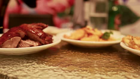 chinese dishes and sauces rotate on a lazy susan in a restaurant setting. warm lighting enhances the inviting atmosphere