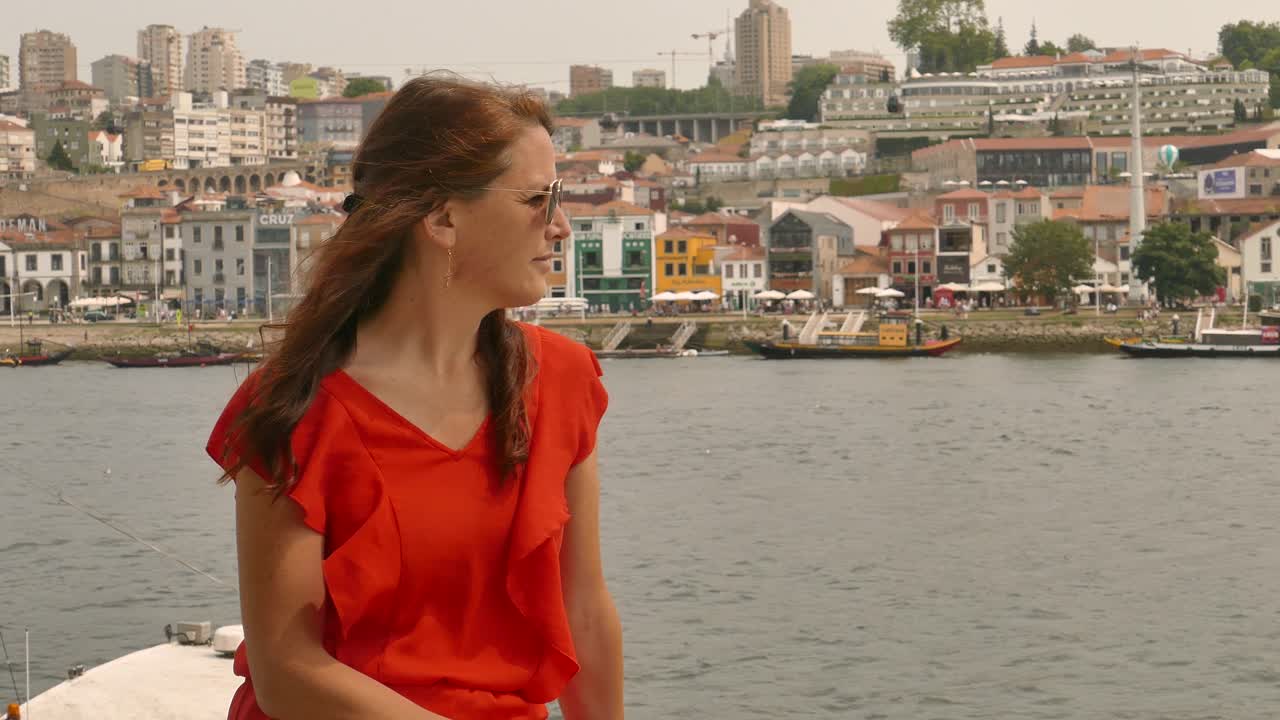 포르투갈 포르투에서 리베이라 해변 에 앉아 있는 매력적 인 여자 와 배경 에 있는 빌라 노바 데 가이아