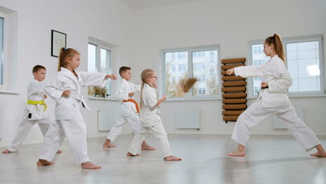 niños en kimono blanco en la clase de artes marciales