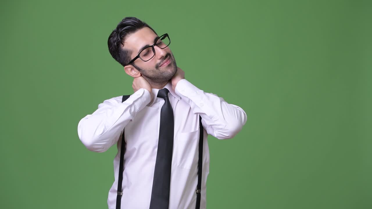 緑の背景をバックにした、若くてハンサムなひげのペルシャ人ビジネスマン