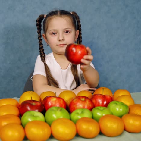 portrait of a little girl with many fresh fruit. ripe organic fruit nicely composed on the table and cute little girl playing with them.
