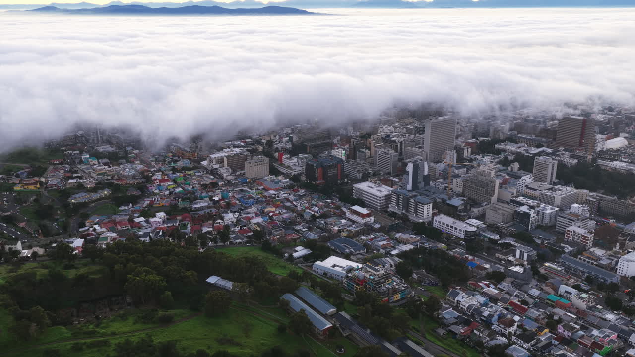 Cape Town’s skyline peeks out as thick clouds roll over the city, merging urban structures with dramatic nature in a breathtaking aerial view