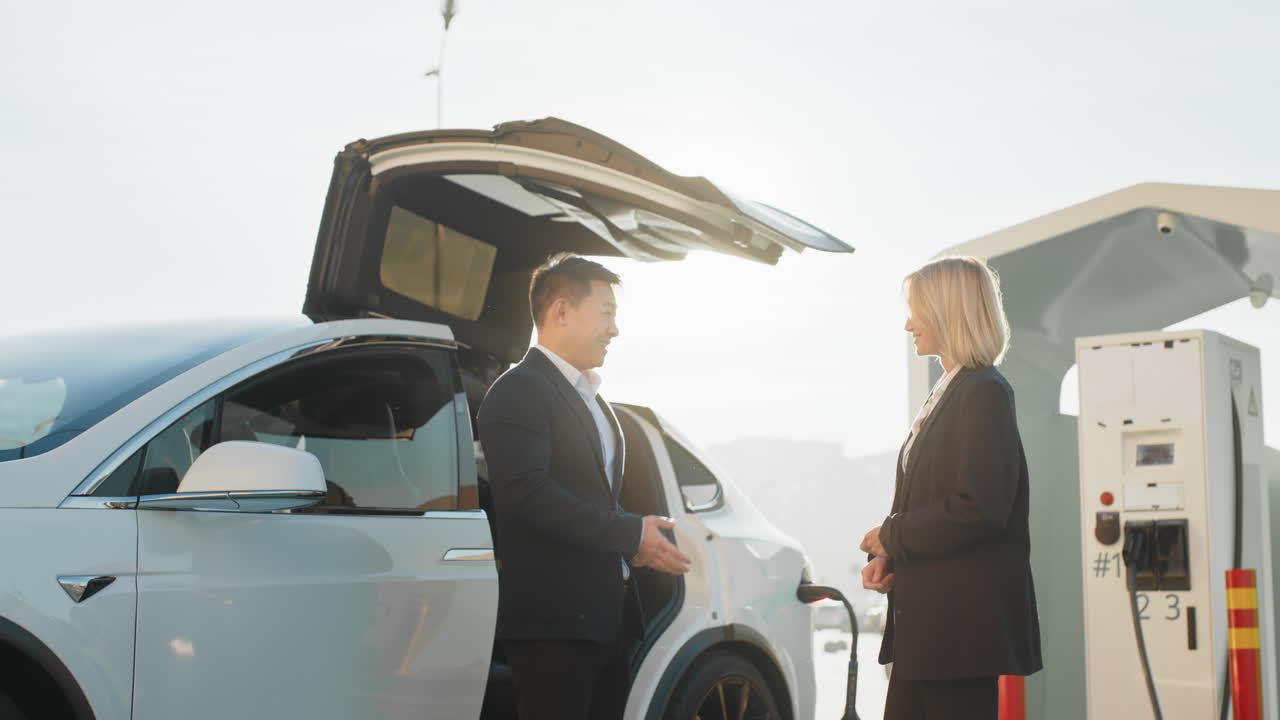 전기차 충전소 에서 열 를 교환 하는 사업가 들