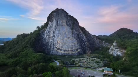 Imágenes-De-Drones-De-4k-De-La-Montaña-De-Buda-En-Pattaya-Donde-Una-Imagen-De-Buda,-Sentado-Con-Las-Piernas-Cruzadas,-Fue-Grabada-En-Oro-En-La-Cara-Norte-De-Una-Colina-De-Piedra-Caliza-En-Khao-Chi-Chan,-Tailandia