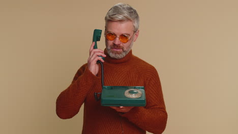 Ein-Alter-Mann-Mittleren-Alters,-Der-An-Einem-Kabelgebundenen,-Altmodischen-Vintage-Telefon-Mit-Werbung-Aus-Den-80er-Jahren-Spricht,-Ruft-Mich-Zurück