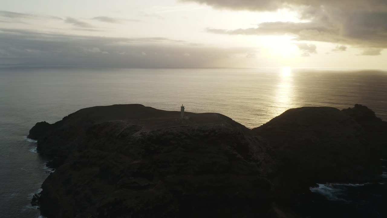 Silhouette of Lighthouse on Ilhéu de Ferro with bright sunlight at dusk