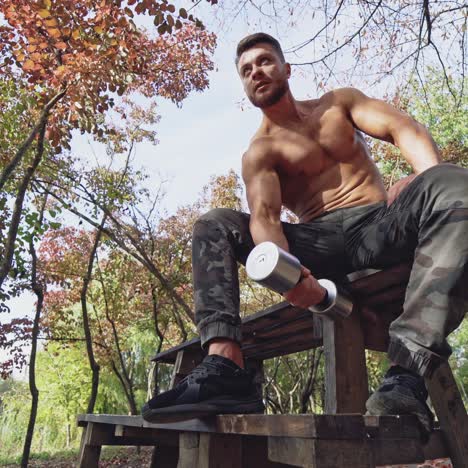 . man doing exercise with dumbbell. portrait of man exercising with dumbbell in park