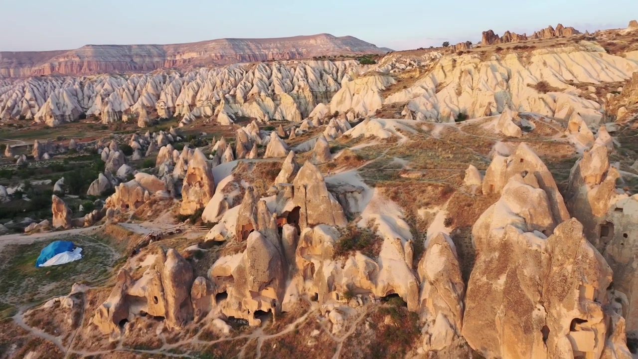 Vista aerea dall'alto con drone di antiche abitazioni rupestri e storiche case-grotta scavate nel tufo vulcanico a Goreme, Cappadocia, Nevsehir, Turchia, all'ora d'oro