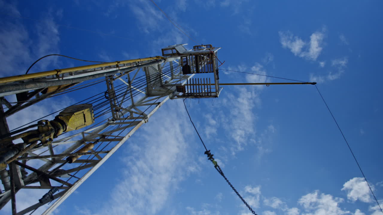Metal support for the equipment drilling oil and gas. Low angle view on the tower at the site for production of natural resources.