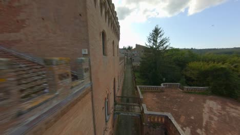 flock of pigeons flying on traditional and brick buildings in sinalunga, siena, italy